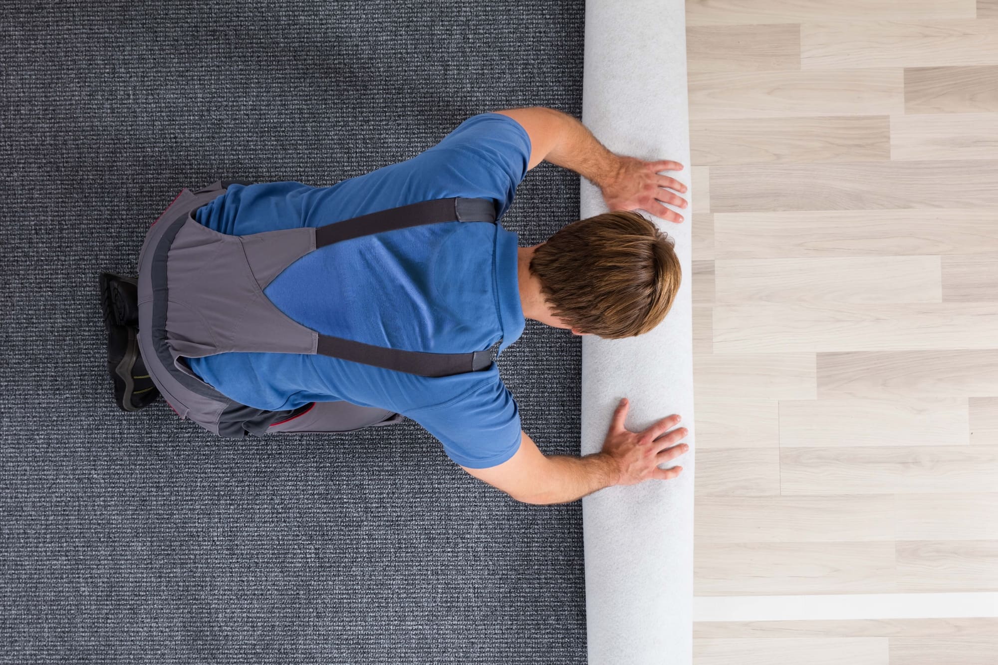 Fitter installing carpet